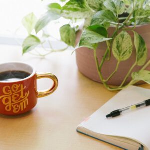 Notebook, pen and coffee for writing a birth plan